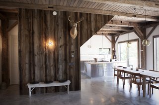 The cabin’s basic structure was reclaimed from a barn built in 1840 and purchased from Heritage Barns out of Waco, Texas. The same company supplied the recycled wood that clads the walls, though the ceiling boards are new. “We stained them with a gray wash to match the tones of the post and beam, but with a more clean look,” Bronee explains. The concrete floors were polished and waxed for a sleek finish.