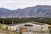 Breaking up the roof planes and concrete floor plates allowed the house to blend into the landscape. The wall that wraps the building ensures it is still a single, coherent form. Photo 3 of Lake Hawea Courtyard House modern home