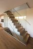 The home’s ground level features engineered oak flooring. The staircase, which leads to the house’s upper and lower levels, was constructed out of steel folded plate and subsequently clad in timber. Photo 6 of Sandpath modern home