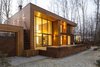 The house has two distinct volumes. The smaller one contains the garage, as well as the heating and air conditioning units, and is topped by a green roof garden accessible by an outdoor staircase. The larger, two-level volume sits slightly above ground and contains the living, dining, and sleeping spaces—all with windows facing east into the forest. Photo 3 of House in Moscow modern home