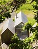 Modern home with Exterior, Gable RoofLine, and House. A rear deck is nestled behind the central cabin, flanked by the sleeping quarters. Inside, the dining table sits beneath a single hanging lamp. Photo of This Cozy Retreat Holds the Cure for Cabin Fever
