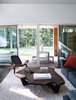 Modern home with Living Room, Chair, Rug Floor, and Coffee Tables. Interior designer Danielle Roberts sought practical materials for the living room, such as custom wide-wale upholstery for a CB2 sofa. The fallen-wood coffee table is by St. Louis–based designer David Stine; the chair is by Hans Wegner for Carl Hansen & Søn. Photo of 17 Modern Homes With Hans Wegner Furniture