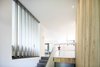 The new upper floor holds three bedrooms and a balcony overlooking the structure's wooded surroundings. The house totals 1,850 square feet. Photo of Sleek Renovation on a Tree-Lined Street in Quebec City modern home