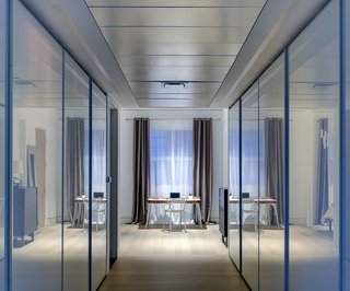 In a home where transitional spaces like corridors and closets had no natural light, the use of white glass doors for the closets help bounce light and maximize light reflections.