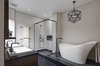 In the master bathroom, Nero Marquina marble floors by Ann Sacks surround an elegant Hastings soaking tub. Duravit sinks, Kallista faucets, Ann Sacks wall tile, and custom walnut cabinetry complete the space. Photo of A Bright Brooklyn Loft with an Envy-Inducing Walk-In Closet modern home