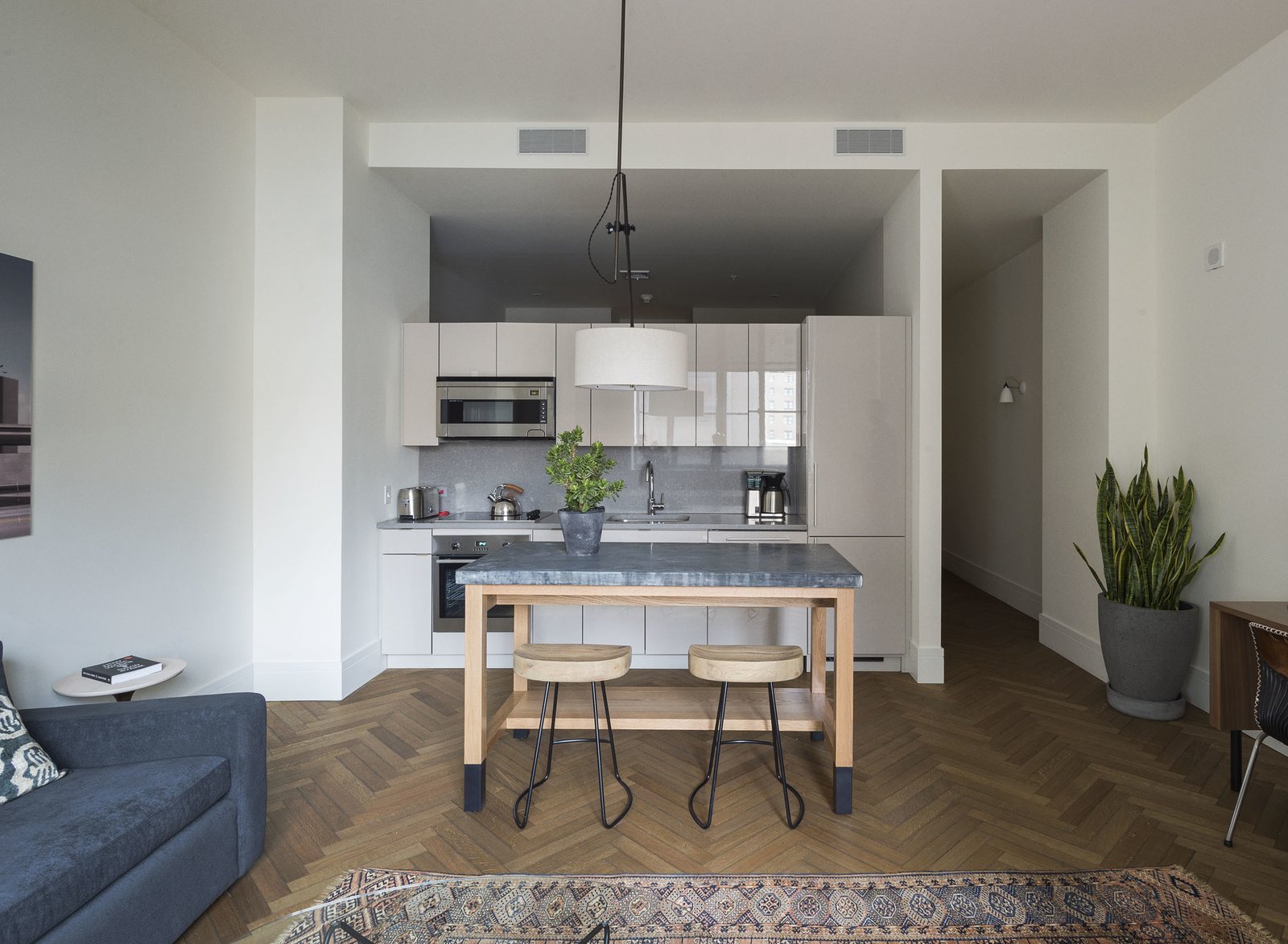 Four layouts are available, though the majority of the 27 units are one-bedrooms. Each contains a full kitchen. The custom millwork and metalwork throughout is by Amuneal.