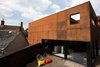 With the challenge of fitting a four bedroom house on an oddly shaped plot, Merer's design aimed to maximize space. Cor-Ten steel makes up the home's distinctive exterior, a nod to the site's industrial roots. Glass, steel, and wood intersect on the second floor wrap-around deck. Photo of Ferrum House modern home
