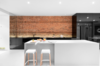 Modern home with Kitchen, White Cabinet, Brick Backsplashe, Engineered Quartz Counter, Recessed Lighting, Cooktops, Drop In Sink, Refrigerator, and Concrete Floor. An illuminated brick wall makes a lovely backdrop when juxtaposed against this kitchen's glossy black cabinets. Photo of A Futuristic Apartment with a Glass-Enclosed Bedroom