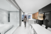 Modern home with Dining Room, Table, Chair, and Pendant Lighting. A radiant hot water heating system was installed under a new concrete floor slab above the old foundation. It was coated with epoxy — light gray for the common areas, white for the bedrooms and bathrooms — then finished with matte polyurethane. Photo of A Futuristic Apartment with a Glass-Enclosed Bedroom