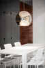 Modern home with Dining Room, Table, Pendant Lighting, and Chair. Goneau matched Audrey Chairs from Kartell with a dining table she designed herself. “It becomes the visual continuity of the kitchen island, by its dimensions and material,” she says. A bronze copper pendant by Tom Dixon hangs above it. Photo of A Futuristic Apartment with a Glass-Enclosed Bedroom
