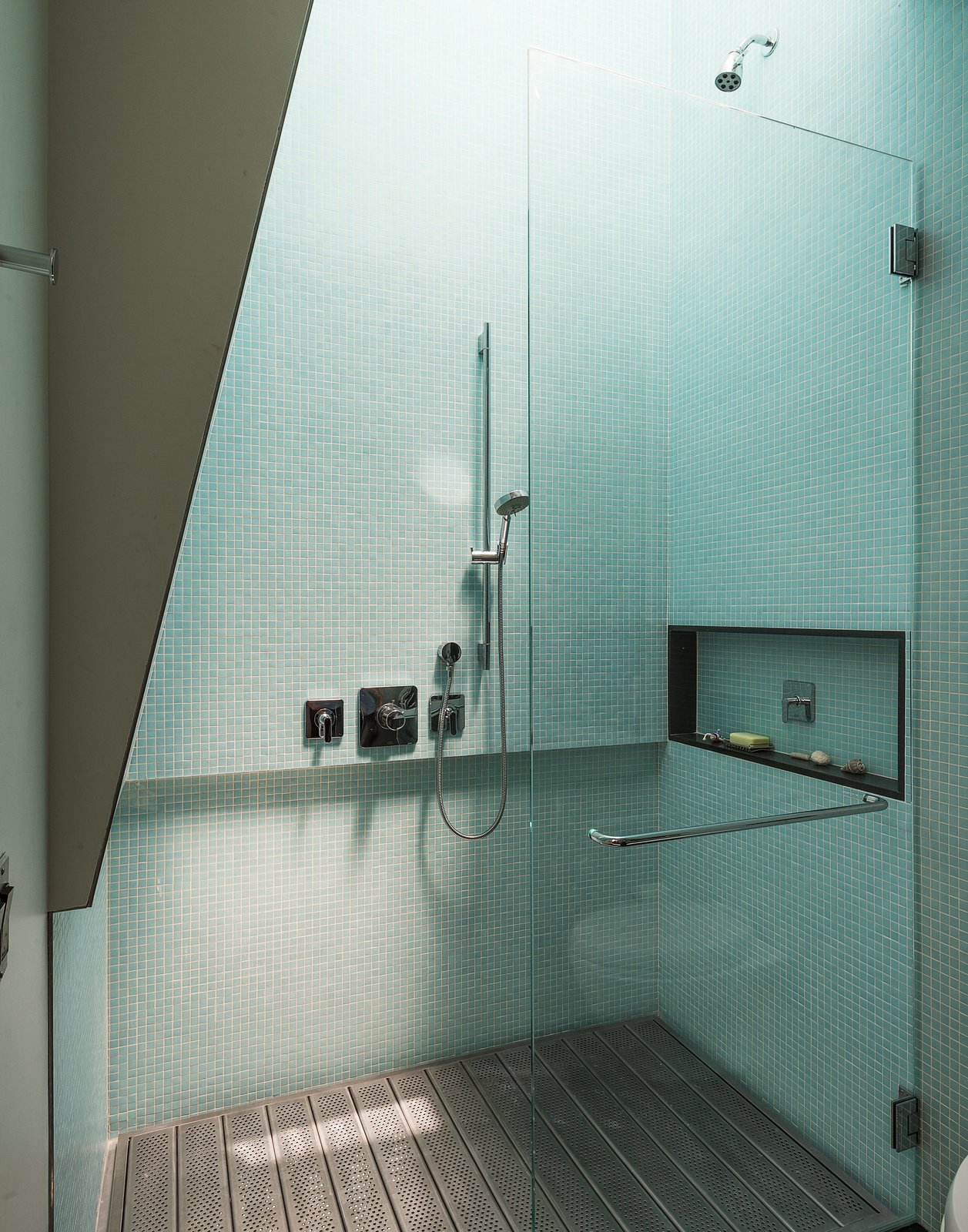 The upstairs showers are particularly ingenious: Operable skylights loom above, and perforated, galvanized-steel platforms open up to spacious, sunken bathtubs.