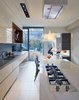 Modern home with Kitchen, Marble Counter, and Cooktops. Dubbeldam opened up the layout completely—long linear elements draw your eyes through the house to the backyard, and subtle details guide your eye there. One type of porcelain tiles, intended for outdoor use, stretches from the kitchen to the yard. "The backyard is small," she says, "but when you connect the house and the yard visually, they both seem so much larger." Photo of Through House in Toronto, Canada