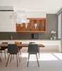 A custom unit of sapele wood holds three masks that evoke Patel's East African heritage. Dubbeldam designed the built-in dining table out of solid sapele. The backsplash and counter are made of gray St. Marks limestone. Photo of Through House in Toronto, Canada modern home