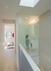Upstairs, an operable skylight lets hot air vent straight out of the house, and also brings light in to the adjacent bathroom—through a frosted glass wall—and the downstairs. Photo of Through House in Toronto, Canada modern home