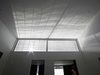 The horizontal aluminum slats that make up the reflector screen help cut down on glare as light flows through the front of the home. Interior walls are the canvas for a delicate movement of light and shadow. The screen, explains architect Paul Raff, "creates a beautiful pattern of reflections that shift across the space minute by minute, and hour by hour." Photo of A Modern Toronto House Covered by a Contemporary Solar Screen modern home