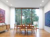 The leafy backyard is the backdrop for the family's dining room. Walnut hardwood flooring adorns the space, along with a vintage Danish modern dining set and sideboard. Photo of A Modern Toronto House Covered by a Contemporary Solar Screen modern home