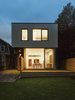 Modern home with Exterior, House Building Type, and Flat RoofLine. Light illuminates the back of the home at night. The Vicenza flamed basalt exterior and floor-to-ceiling windows are a bold counterpoint to the house's more traditional neighbors. Photo of A Modern Toronto House Covered by a Contemporary Solar Screen
