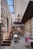 Modern home with Staircase, Glass Railing, and Metal Tread. Irit and Zohar imagined a space that would be a cohesive blend of old and new. Stone, metal, glass, and wood intersect in the interior courtyard. Large skylights bring light in, and play upon the indoor-outdoor functionality of the courtyard space. Photo of A 250-Year-Old Stone House in Israel with a Surprisingly Modern Interior
