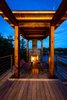 A covered fireplace and sitting area anchor the deck, which overlooks the water. Photo 3 of Monument Channel Cottage modern home
