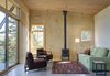 While the home is well insulated on all sides, the hearth can provide extra warmth when necessary. Photo of Simple Cabin Embraces Its Mountain Setting modern home