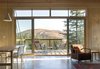 Supported by steel strips, the balcony extends outwards to meet the valley below. Fully-glazed sliding doors and a clerestory window provide a view. Photo of Simple Cabin Embraces Its Mountain Setting modern home
