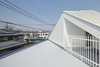 Seen from above, the two houses look like triangles joined at their long edge to form a square. The side facing the street is curved, presenting what Nakasa calls a “morphological contrast” with the gable roof peeking out behind. Photo 2 of Half & Half House modern home