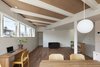 The ceilings of the two houses were at slightly different heights, an incongruity Nakasi played up for visual punch. He exposed the beams in the higher ceiling and painted them white to match the smooth finish of the lower one. The desk beneath the window is from Muji. Photo 4 of Half & Half House modern home