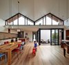 The roof’s geometric shape helps the interior feel more expansive than it is. Messmate timber floorboards and painted ceiling boards follow the lines of its double hip and draw the eyes upward. Powder-coated black aluminum window frames also accentuate its form. “We like the contrast of the white space with the gutsy black frames,” Bright says. Photo 3 of M House modern home