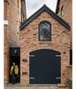 Modern home with Exterior, House, Brick Siding Material, and Gable RoofLine. Faux timber doors, painted black, along with a brick facade help the dwelling blend with its surroundings: the Victorian homes of the Moseley neighborhood in Birmingham, UK. Photo of We Love This Adorable Writer's Studio Camouflaged as a Coach House