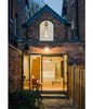 The home's rear is thoroughly modern. Blue bricks, salvaged from the preexisting building, are now the pavers in the entrance and patio. Photo of We Love This Adorable Writer's Studio Camouflaged as a Coach House modern home