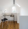 A compact workspace is perched atop the mezzanine level and has views to the garden in the rear. Photo of We Love This Adorable Writer's Studio Camouflaged as a Coach House modern home