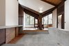 The dining room opens up to the new concrete hearth. Old plans indicate this area was originally intended to be an open courtyard, however, the original clients enclosed it with a leaky glass canopy. The architects installed a new sloped roof that quickly channels away rainfall. The fireplace is composed of brick salvaged from the original floor and the new concrete floor features increased insulation. Photo 6 of Zema Redux modern home
