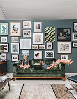 In the playroom, a velvet Desiron sofa is set off by Down Pipe paint from Farrow & Ball.