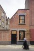 Set in a conservation area, the home’s façade was designed to blend into the street’s terrace style. To that end, it is clad in red bricks from Traditional Brick & Stone and punctuated with sash windows. The concrete toned lintels hint subtly at the modernity that lies within. Photo of Cleverly Stacked Floors Form a Roomy House On a Tight Lot modern home