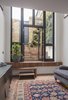 Modern home with Living Room and Bench. The home’s living room is located on the lower level, opposite the kitchen. The herringbone-patterned brick floor is partially covered by a carpet purchased in Istanbul. A sofa and Muuto sideboard anchor opposite sides of the space. Photo 4 of Cleverly Stacked Floors Form a Roomy House On a Tight Lot
