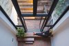 Viewed from above, the lower level’s brick floors establish a sense of continuity between the living spaces and the outer courtyard. Two-stories of glazing ensure that the lower levels never feel gloomy. Photo 5 of Cleverly Stacked Floors Form a Roomy House On a Tight Lot modern home