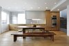 Modern home with Dining Room, Bench, Table, and Medium Hardwood Floor. "Many of the decisions were about maximizing luminosity within the apartment," principal James Slade says. The open-plan kitchen and dining room features a custom walnut picnic-style table. Photo of Modern Dream Penthouse in New York City Makes the Most of Natural Light