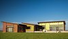 Modern home with Exterior, Wood Siding Material, House, and Green Roof Material. The paint does more than add visual interest, it contributes to the net-zero home's overall sustainability. On the roof, which features an impressive solar array, Valspar’s Fluropon coating in Surrey Beige heightens solar reflectivity. Photo of 16 Funky Facades