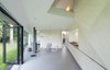 In the sparse living area, two gray Gispen chairs designed by Wim Rietveld sit around a standalone wood stove. A Slow Glow Lamp designed by Aura Luz Melis for Droog Design hangs at the room's center. Photo 5 of Triangular House modern home