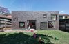 Modern home with Exterior, House Building Type, and Brick Siding Material. The bungalow had beautiful bones but some major problems, including a poorly designed addition to the back that had to be removed. In its place, Tribe Studio designed a gray brick box that connects directly to the garden. “The owners love the fact that the extension is compatible with the old part of the house, and is completely different from many renovations of this type, which simply open up the back in a single move,” Tribe says. Photo of A Traditional 1920s Bungalow with a Boxy Modern Extension