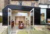 Modern home with Doors, Exterior, and Swing Door Type. The slightly below-ground kitchen sits inside a boxy extension, clad in recycled timber and stained kettle black. A wildflower garden grows on its pitched roof. Photo of A Modern Addition Gives a London Chef a Dream Kitchen
