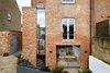 A tall and narrow window separates the new brickwork from the historic building, making its lines and profile clearly understandable. Photo of Lantern Home modern home