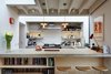 Modern home with Kitchen, Concrete Counter, and Subway Tile Backsplashe. “The client wanted an interior space where you could read the materiality of the building elements like understanding the ingredients in a recipe,” principal architect Elizabeth Webster explains. The extension features distinctly textured materials: an exposed timber ceiling, painted brick walls, and polished concrete floors. Warm lighting by Brinklicht unifies the space. Photo of A Modern Addition Gives a London Chef a Dream Kitchen