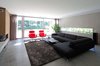 The living room opens to the backyard thanks to a large sliding glass door. Photo of A Dutch Home that Plays with Traditional Brick Architecture modern home