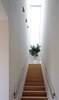 The staircase divides the house in two, separating the kitchen from the other living spaces. A large skylight lets in ample illumination. Photo of A Dutch Home that Plays with Traditional Brick Architecture modern home