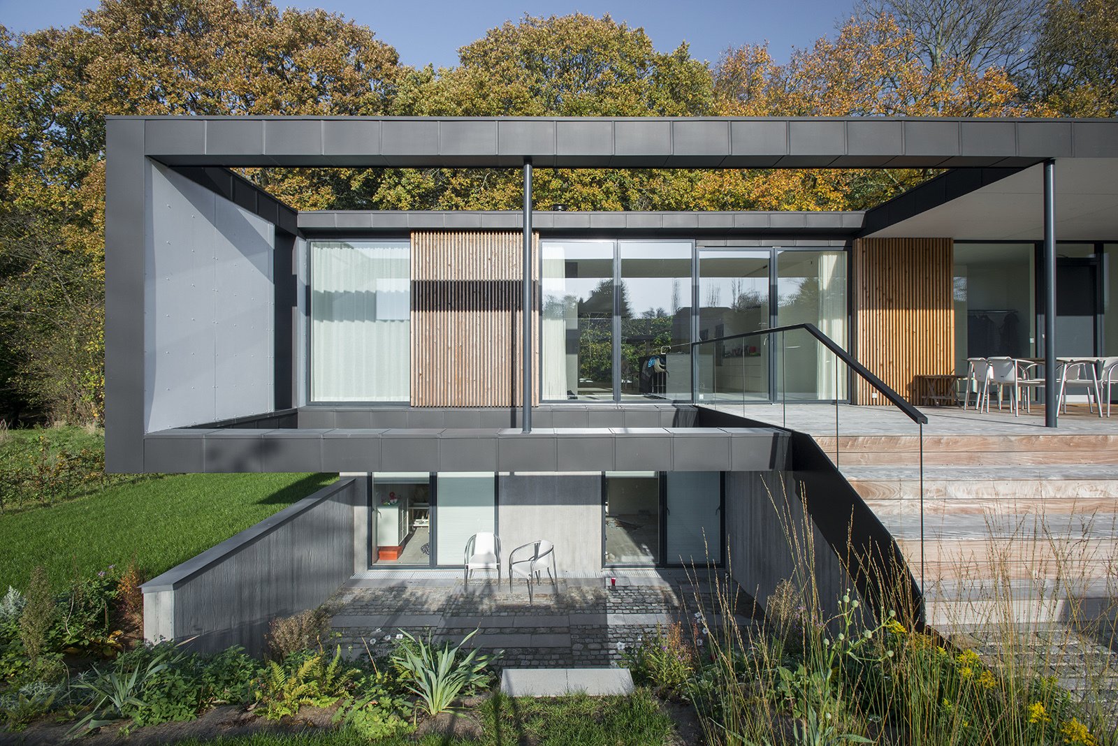 Located in Aarhus, Denmark, Villa R is a minimalist, serene structure clad in zinc panels. "The objective was to create a house that brings the forest inside through large glass panels—and create an ever-changing seasonal backdrop for the interior living spaces," stated the architecture firm, C.F. Møller, of the 3,200-square-foot abode.
