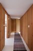 Modern home with Hallway. Douglas fir lines the walls of the entryway. A narrow striped rug adds texture to the white-painted wooden floor from Dinesen. Photo of A Thatched Cottage in Denmark with a Modern, Space-Saving Interior