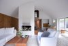 Lassen designed all the furniture with the exception of a few items, like the vintage Chairman armchair by Henrik Tengler and white IKEA sofas. “To keep it simple, we only used natural colors from wood inside, with everything else being white,” Lassen says. Photo of A Thatched Cottage in Denmark with a Modern, Space-Saving Interior modern home