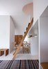 A small dining room occupies the space just beyond the living room. It’s furnished with vintage folding chairs designed by Danish architect Mogens Koch that are easily stored for more space. Photo of A Thatched Cottage in Denmark with a Modern, Space-Saving Interior modern home