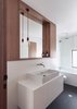 Modern home with Bath Room and Vessel Sink. As in the kitchen, the bathroom features custom wooden cabinetry and Brodware faucets. Photo of A Traditional 1920s Bungalow with a Boxy Modern Extension